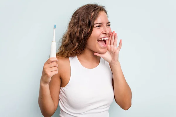 Ung Kaukasisk Kvinna Som Håller Elektrisk Tandborste Isolerad Blå Bakgrund — Stockfoto