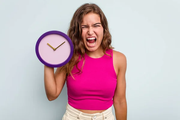 Joven Mujer Caucásica Sosteniendo Reloj Aislado Sobre Fondo Azul Gritando —  Fotos de Stock