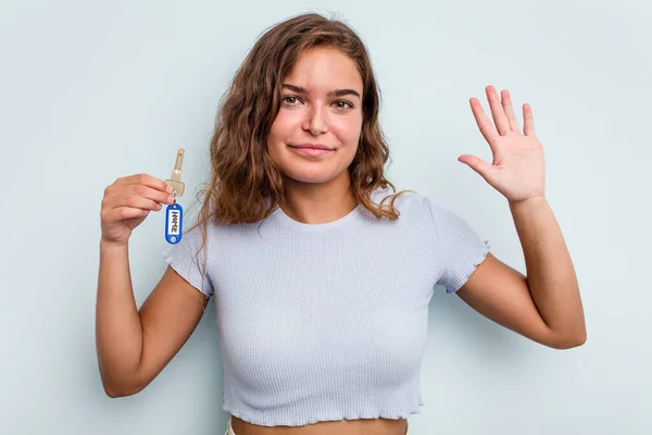 Young Caucasian Woman Holding Home Keys Isolated Blue Background Smiling — Stok fotoğraf