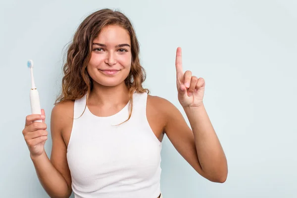 Young Caucasian Woman Holding Electric Toothbrush Isolated Blue Background Showing — Stock Photo, Image