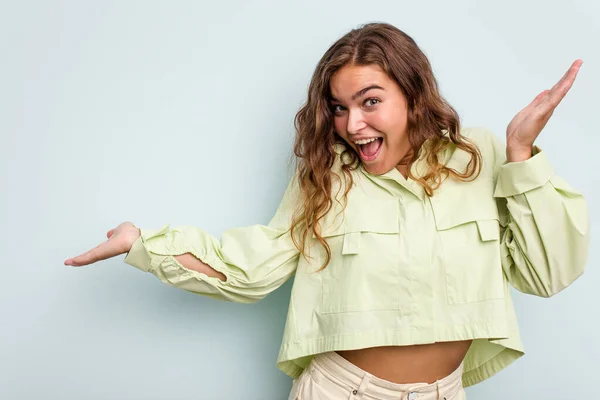 Joven Mujer Caucásica Aislada Sobre Fondo Azul Sostiene Espacio Copia — Foto de Stock