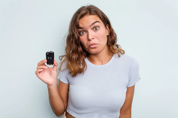 Young Caucasian Woman Holding Car Keys Isolated Blue Background Shrugs — ストック写真