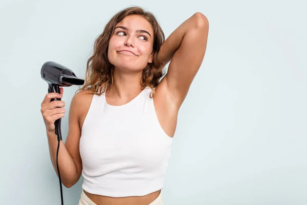 Young Caucasian Woman Holding Hairdryer Isolated Blue Background Touching Back — Stock Photo, Image