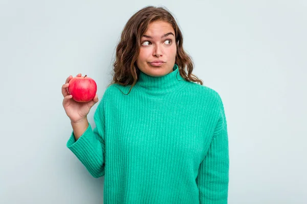 Junge Kaukasische Frau Mit Einem Auf Blauem Hintergrund Isolierten Apfel — Stockfoto