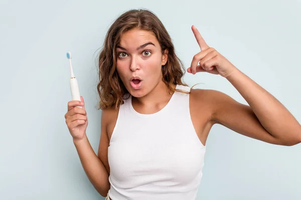 Joven Mujer Caucásica Sosteniendo Cepillo Dientes Eléctrico Aislado Fondo Azul — Foto de Stock