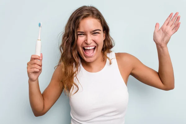 Junge Kaukasische Frau Mit Elektrischer Zahnbürste Isoliert Blauen Hintergrund Erhalten — Stockfoto