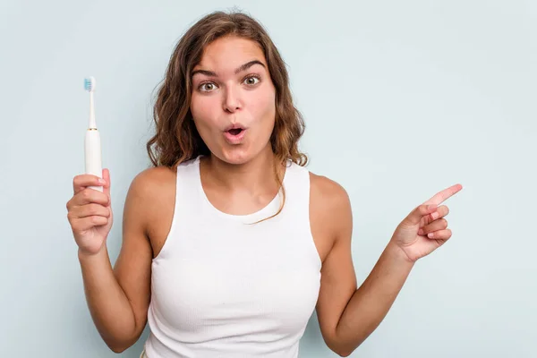 Joven Mujer Caucásica Sosteniendo Cepillo Dientes Eléctrico Aislado Fondo Azul — Foto de Stock