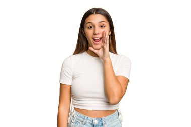 Genç Hintli kadın kesme izole arka plan yüksek sesle bağırıyor, gözleri açık ve elleri gergin tutuyor.