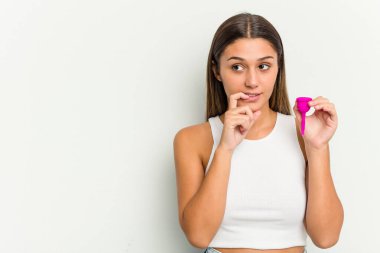 Beyaz arka planda izole edilmiş adet bardağını tutan genç bir kadın bir şeyin fotokopi odasına baktığını düşünerek rahatlıyor..