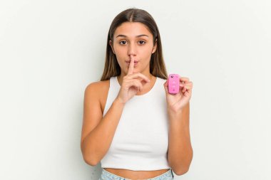 Genç Hintli kadın elinde elektronik pembe bir araba anahtarı tutuyor ya sır saklıyor ya da sessizlik istiyor..