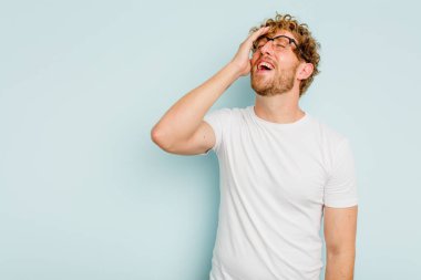 Kafkasyalı genç adam mavi arka planda yalnızdı gülerek, kaygısızca, doğal duygularla.