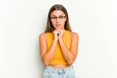 Genç Hintli bir kadın beyaz arka planda izole edilmiş şans için dua ediyor, şaşırmış ve ağzını açıp önüne bakıyor..