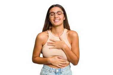 Genç Hintli bir kadın, kesme izole edilmiş arka plan mutlu bir şekilde gülüyor ve ellerini karnının üstünde tutarak eğleniyor..