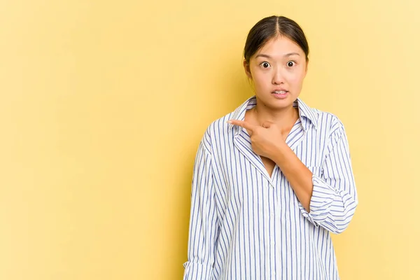 Jonge Aziatische Vrouw Geïsoleerd Gele Achtergrond Wijzend Naar Zijkant — Stockfoto