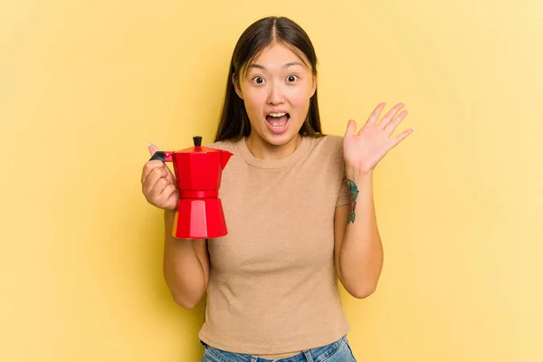 Jonge Aziatische Vrouw Houden Koffiezetapparaat Geïsoleerd Gele Achtergrond Het Ontvangen — Stockfoto