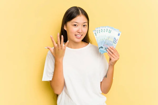 Young Asian Woman Holding Banknotes Isolated Yellow Background Smiling Cheerful — Stock Photo, Image