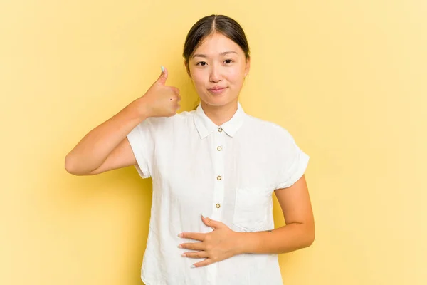Jonge Aziatische Vrouw Geïsoleerd Gele Achtergrond Raakt Buik Glimlacht Zachtjes — Stockfoto