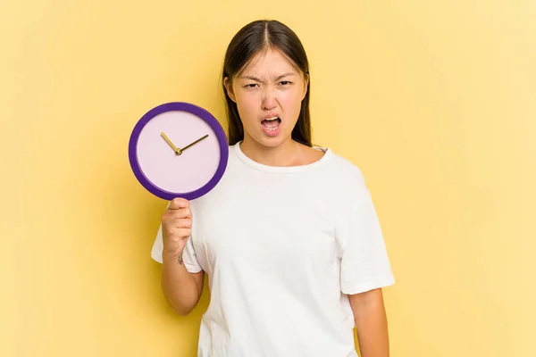 Jovem Mulher Asiática Segurando Relógio Isolado Fundo Amarelo Gritando Muito — Fotografia de Stock