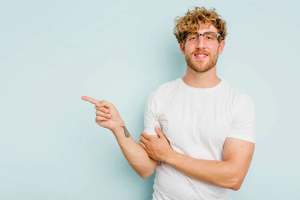 Joven Hombre Caucásico Aislado Sobre Fondo Azul Sonriendo Alegremente Señalando — Foto de Stock