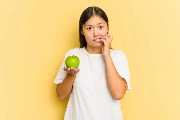 Giovane Donna Asiatica Mangiare Una Mela Isolata Sfondo Giallo Mordere — Foto Stock