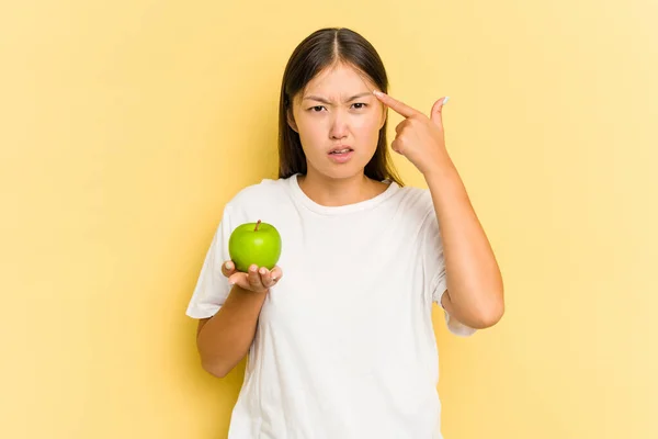 Joven Asiática Comiendo Una Manzana Aislada Sobre Fondo Amarillo Mostrando —  Fotos de Stock