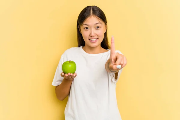 Ung Asiatisk Kvinna Äter Ett Äpple Isolerad Gul Bakgrund Visar — Stockfoto