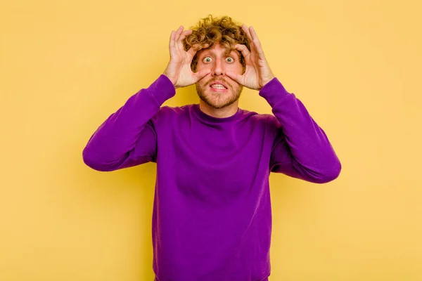 Jovem Caucasiano Isolado Fundo Amarelo Mantendo Olhos Abertos Para Encontrar — Fotografia de Stock