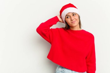 Genç Hintli kadın Noel 'i beyaz arka planda yalnız kutluyor. Başının arkasına dokunuyor, düşünüyor ve bir seçim yapıyor..