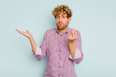 Kafkasyalı genç adam mavi arka planda izole edilmiş..