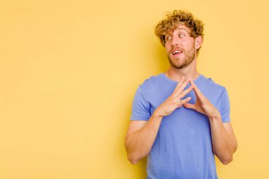 Kafkasyalı genç bir adam sarı arka planda izole edildi. Aklında bir plan oluşturdu..