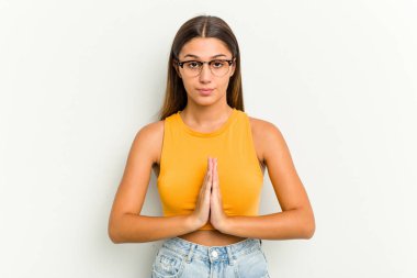 Genç Hintli kadın beyaz arka planda izole edilmiş dua ediyor, bağlılık gösteriyor, dindar biri ilahi ilhamı arıyor..