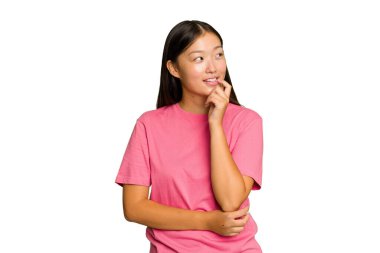 Yeşil krom arka planda izole edilmiş genç Asyalı kadın rahatlamış fotokopi alanına bakan bir şey düşünüyor..