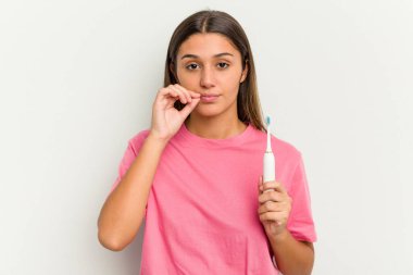 Dişlerini fırçalayan genç bir Hintli kadın beyaz arka planda izole edilmiş parmakları dudaklarında bir sır saklıyor..