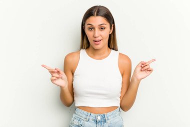 Beyaz arka planda izole edilmiş genç Hintli kadın farklı kopya alanlarını gösteriyor, birini seçiyor, parmaklarıyla gösteriyor..