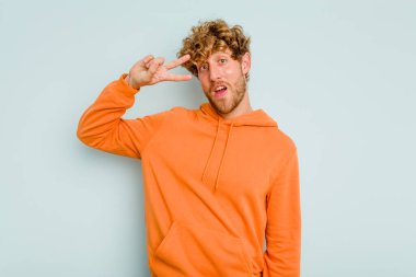 Genç beyaz adam mavi arka planda izole edilmiş dans ediyor ve eğleniyor..