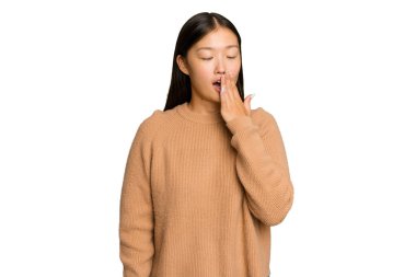 Genç Asyalı kadın yeşil renkli arka planda izole edilmiş esniyor. Ağzı eliyle kapatan yorgun bir hareket sergiliyor..