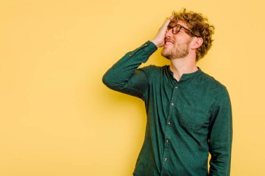 Sarı arka planda izole edilmiş genç beyaz adam gülüyor, kaygısız, doğal duygu..