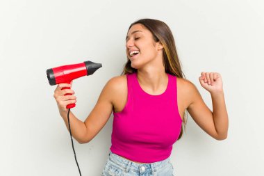 Beyaz arka planda izole edilmiş bir saç kurutma makinesi tutan genç Hintli kadın.