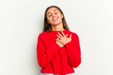 Beyaz arka planda izole edilmiş genç bir Hintli kadın, avuçlarını göğsüne bastıran dostane bir ifadeye sahiptir. Aşk konsepti.