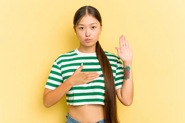 Ung Asiatisk Kvinna Isolerad Gul Bakgrund Sätta Handen Bröstet — Stockfoto