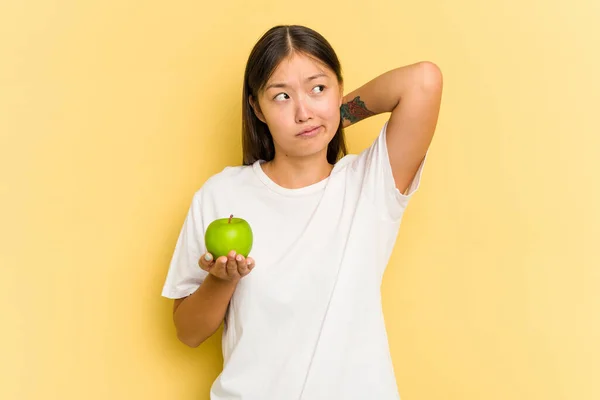 Junge Asiatin Isst Einen Apfel Isoliert Auf Gelbem Hintergrund Berührt — Stockfoto