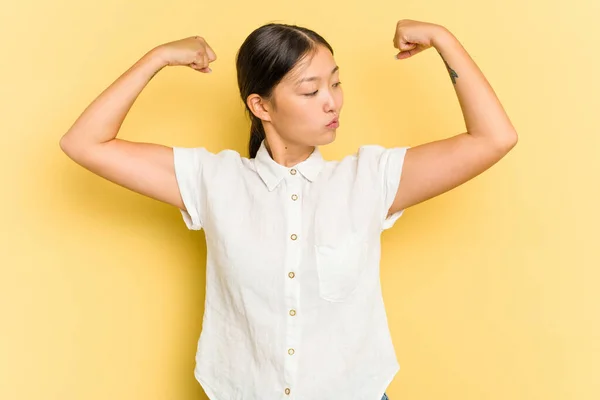 Mujer Asiática Joven Aislada Sobre Fondo Amarillo Mostrando Gesto Fuerza —  Fotos de Stock