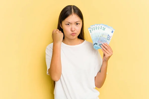 Young Asian Woman Holding Banknotes Isolated Yellow Background Showing Fist — Stock Photo, Image
