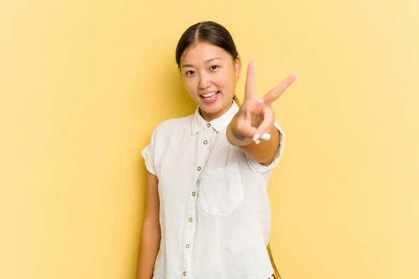 Junge Asiatin Auf Gelbem Hintergrund Fröhlich Und Unbeschwert Zeigt Ein — Stockfoto