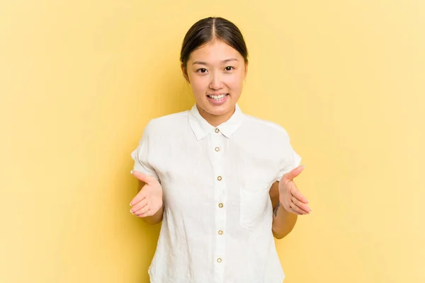 Junge Asiatin Auf Gelbem Hintergrund Isoliert Etwas Mit Beiden Händen — Stockfoto