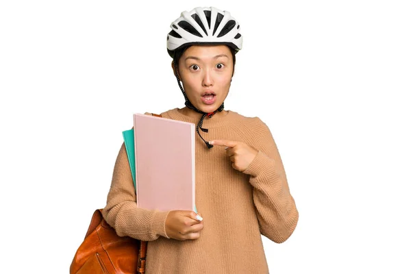 年轻的亚洲学生女子戴着自行车头盔 与绿色背景隔离 指向侧面 — 图库照片
