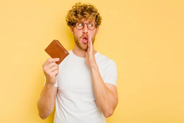 Young Caucasian Man Holding Wallet Isolated Yellow Background Saying Secret — Stock Photo, Image