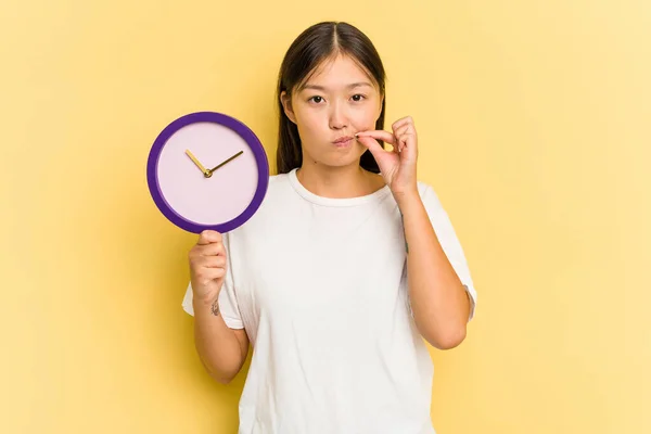 Joven Mujer Asiática Sosteniendo Reloj Aislado Sobre Fondo Amarillo Con — Foto de Stock