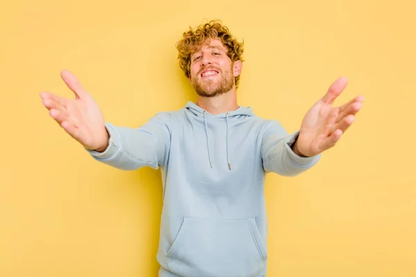 Young Caucasian Man Isolated Yellow Background Feels Confident Giving Hug — Stock Photo, Image