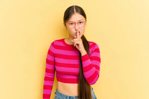Sarı Arka Planda Izole Edilmiş Genç Asyalı Bir Kadın Sır — Stok fotoğraf